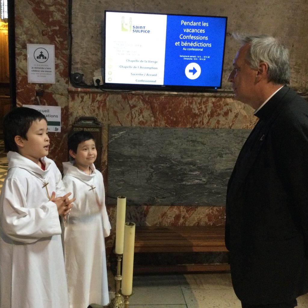 les servants de messe disent bonjour au prêtre.