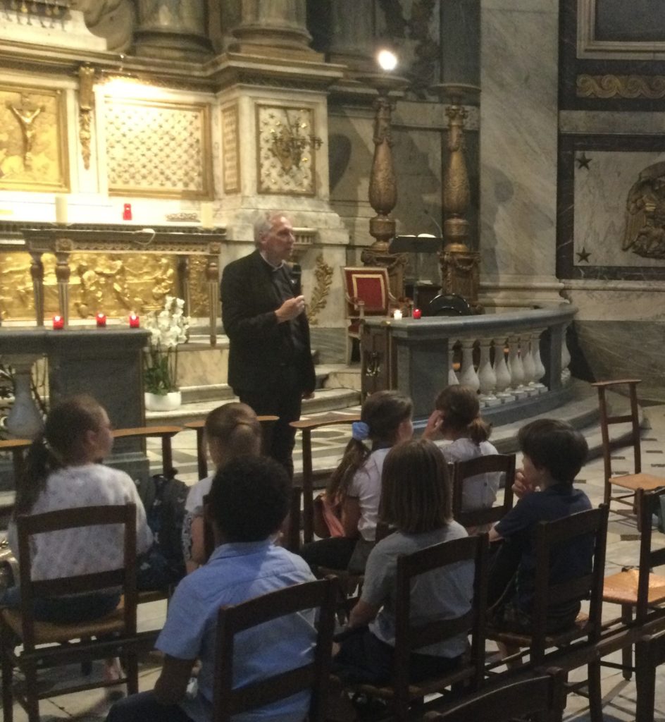l'aumônier du catéchisme parle aux enfants lors de la messe de fin d'année du caté.