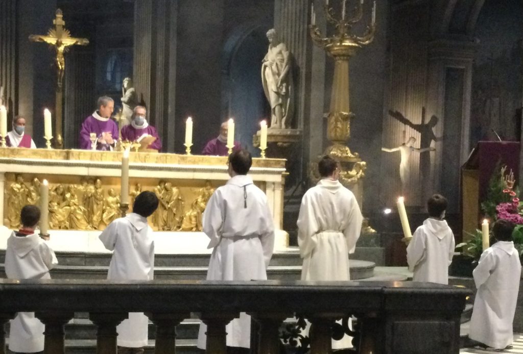 les servants de messe tiennent les cierges lors de la prière eucharistique.
